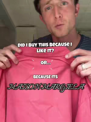 A man holding a pink shirt with text overlayed on it. He is looking at the camera and has text over the shirt.