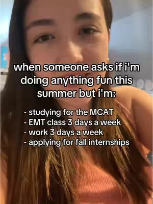 A selfie-style video cover image. The frame captures a woman from the chest up, looking at the camera. She has long brown hair. The background is slightly out of focus, but it seems to be indoors against a blurred blue and red color. Text overlayed on the image details her summer activities.