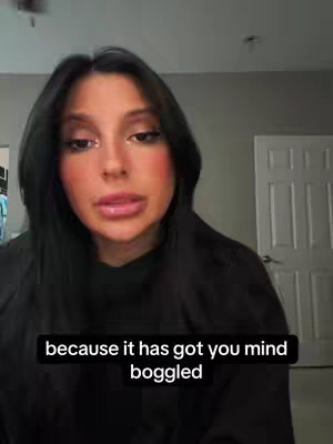 A woman with long dark hair and makeup looks directly at the camera, framed from mid-chest up. A text overlay at the bottom explains something that is happening which is mind-boggling.