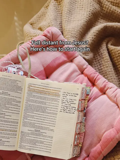 An open Bible with highlighted passages and sticky notes sits on a pink, quilted surface. A tan blanket is in the background. Overlay text reads: Felt distant from Jesus? Here's how to start again.