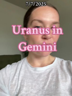 A woman with light skin is centered in the frame, gazing toward the lower right of the image. She is wearing a white t-shirt. The overlay text states 'Uranus in Gemini' in pink rounded letters with a pink outline. Above this text, near the top of the image, is a date stamp, '7/7/2025'. Soft lighting and a neutral background enhance the focus on the central message.
