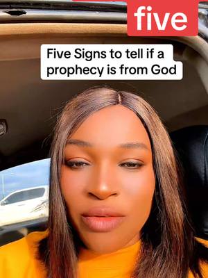 A woman with long brown hair and a yellow shirt is centered in the frame, directly facing the camera. A red rectangular text box with the white word "five" is located at the top right. Below that, a white text box reads "Five signs to tell if a prophecy is from God". The background suggests the interior of a vehicle.
