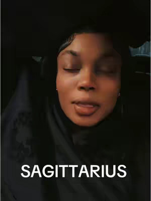 A close-up shot of a person with smooth skin, partly illuminated in a dark setting. The person has closed eyes, a slightly open mouth with the tongue showing and a thin black band around the head. The image has a text overlay at the bottom displaying the word "SAGITTARIUS".