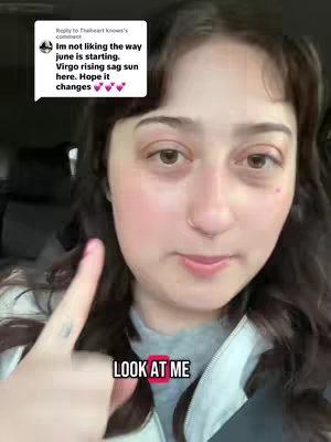 A woman with long, dark hair and fair skin is positioned in front of what appears to be a car interior. She is looking towards the camera, with a finger pointed towards herself. Overlaid on the image are two text elements: a speech bubble with messages from an unknown user concerning Astrology and a red box around the text, "LOOK AT ME."