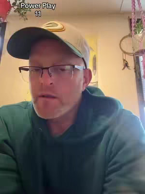A man wearing glasses and a baseball cap looks towards the camera with a focused expression. The background is slightly blurred, showing hints of a room interior. Text overlays indicate the video’s title and a number.