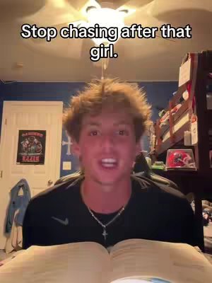 A young man with light brown hair is in a bedroom, speaking toward the camera. Above him is an added text overlay, the text appears to be handwritten and positioned close to the top of the frame.