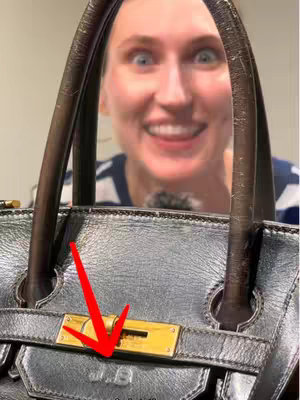 The image shows a woman with wide eyes, and an open mouth, smiling and looking excited. The handles of a dark-colored handbag are in the foreground which obscures parts of her face. An arrow highlights the gold clasp of the bag.