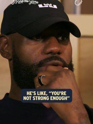 A close-up shot of LeBron James in a black cap, gazing downwards with a thoughtful expression. He is wearing a dark shirt and a ring with black and silver accents. A text box at the bottom contains a quote attributed to him.