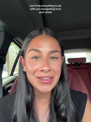 A woman with long dark hair is seen from the chest up, smiling and looking at the camera. The background is blurred, but appears to be the interior of a vehicle. Text overlay at the top reads "but it has everything to do with you recognizing he is your savior".