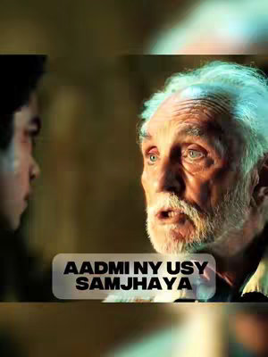 The image shows a scene from a movie, with two men in the frame. On the right side, an older man with gray hair and a white beard looks at another man, who is partially seen on the left side of the frame. They are in an indoor setting with dim lighting, and the text overlay is displayed on a transparent background at the bottom of the image.