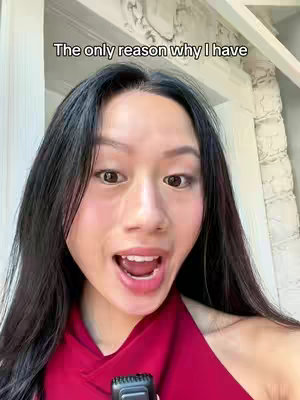 A woman with long black hair and a red top is looking directly at the camera with a surprised expression, her mouth open. Text at the top of the frame reads, 'The only reason why I have.' A window is visible in the background.