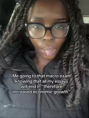 A selfie-style image of a person with dark skin wearing glasses and a black jacket. The person is sticking their tongue out. Text is overlaid on the image.