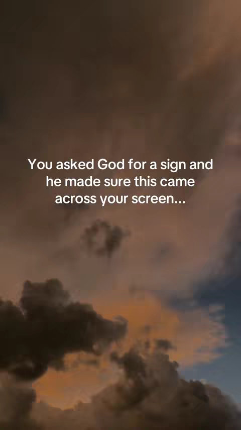 The image displays a cloudy sky at sunset or sunrise. The upper half of the image is dominated by dark, dense clouds, with hints of orange and yellow where the sun is breaking through. The bottom half has a lighter, more open sky with hints of blue. Centered in the image is white text overlaying the sky.
