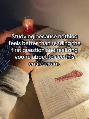 A dimly lit scene featuring a hand holding a tablet displaying code, placed on a wooden surface next to an open textbook with anatomical illustrations and a burning candle in a glass. Overlay text provides a motivational message.