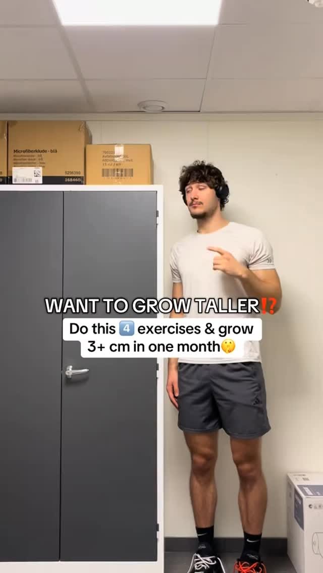 A man stands in a room, pointing upward. Text overlays read, "WANT TO GROW TALLER?!" and "Do this 4 exercises & grow 3+ cm in one month". The background shows a plain wall, a door, and some boxes.