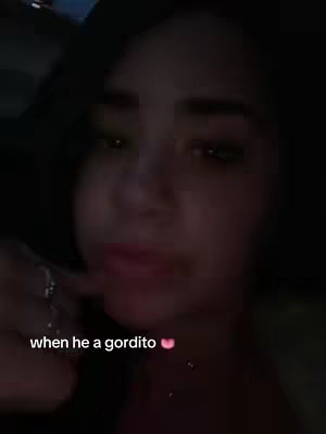 A selfie-style image featuring a person in a dimly lit surrounding. The person appears to be looking towards the camera with the mouth closed. Text overlayed on the image reads 'when he a gordito'.