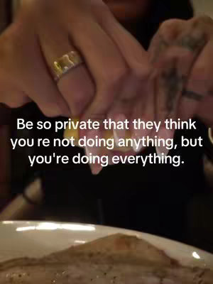 The image shows the hands of a person with a gold ring on the index finger, possibly squeezing something, with text overlay: "Be so private that they think you're not doing anything, but you're doing everything."