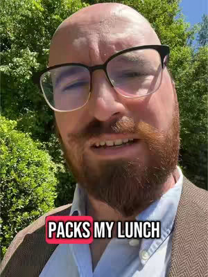 A close-up shot of a man with glasses and a beard, set against a background of green foliage, with the text overlay reading "PACKS MY LUNCH."