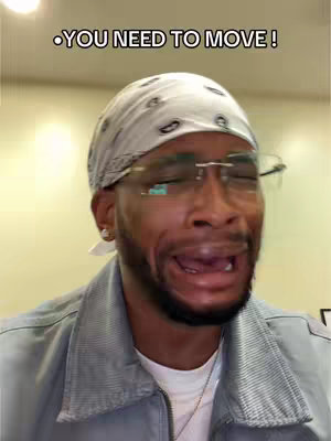 A close-up shot of a Black man with a white bandana and glasses, mouth open in an exaggerated expression. Text overlayed above.