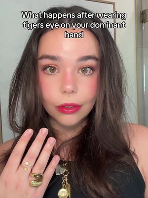 A close-up shot of a young woman with long, dark hair, vibrant makeup, and multiple rings.