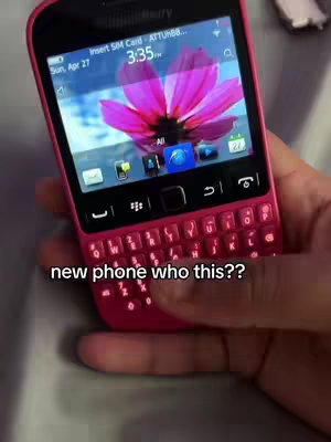 A pink Blackberry phone is held in a hand, showing the screen with a flower wallpaper. The phone's keyboard is visible, along with a text overlay that says 'new phone who this??'.
