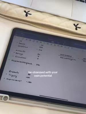 The image shows a tablet displaying what appears to be handwritten notes. A laptop and a pencil case are partially visible in the background. The tablet screen shows financial data, likely related to personal or business finances. Text overlayed on the image reads, "be obsessed with your own potential!"