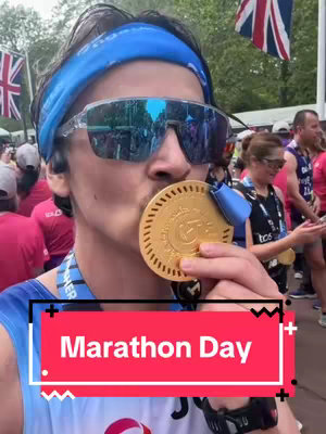 A man wearing sunglasses and a blue headband kisses a gold medal. The background includes people, flags, and a banner with the text 'Marathon Day'. A text overlay with the same text is present at the bottom.