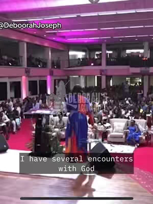 A video of a large gathering in an auditorium or church-like setting, with a person giving a presentation or sermon from a stage. The focus is on the speaker and the audience. The lighting is bright, with a mix of natural and artificial sources. A text overlay states, "I have several encounters with God."