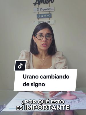 A woman with dark hair and glasses is centered in the shot, speaking directly to the viewer. Behind her is a light-colored wall with decorative wooden elements and a sign with inspirational text. The overlay features text in a white rectangle, and beneath it is more overlaid text explaining the video's topic.