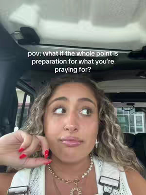 A selfie-style shot taken from inside a car, with the focus on a woman's face. The woman has long, wavy hair and is wearing a necklace. Text overlayed on the image reads, 'pov: what if the whole point is preparation for what you're praying for?' The background is slightly blurred, showing the interior of the vehicle.