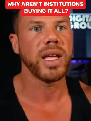 A close-up of a man speaking, with a red rectangular text overlay. The man has fair skin, blue eyes, and a trimmed brown beard. The text overlay is red with white text. The background is dark with some blurred elements suggesting an office or studio setting.