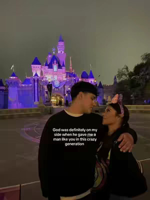 A couple in front of a Disney castle at night, with the castle lit up with blue and purple lights. The couple is embracing and looking at each other. Text overlayed on the image.