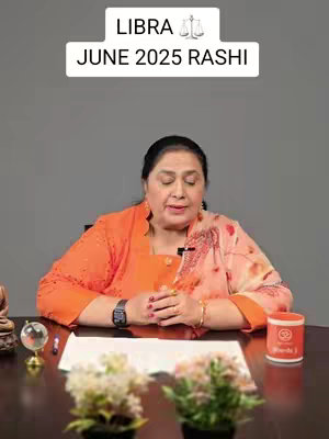 A woman with dark hair wearing an orange top and a patterned shawl sits at a table. The text overlay at the top reads 'LIBRA' and 'JUNE 2025 RASHI'. A variety of objects in the foreground and behind the creator, including flowers, and a small globe.