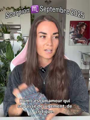 A woman with long brown hair is centered, holding a deck of cards and speaking. Text overlays at the top declare "Scorpion m Septembre 2025". Additional text is displayed near the bottom. The background features plants and a glimpse of a home interior.