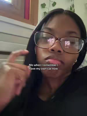 A selfie with a black woman wearing glasses, the reflection of a person in the glasses.