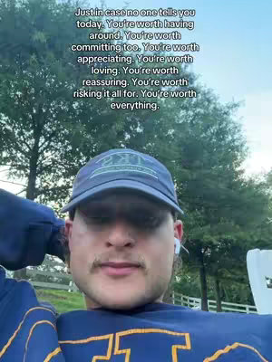 A selfie of a young man in a blue cap and a blue and yellow top. He is smiling and looking at the camera. Text overlays are in the top left.