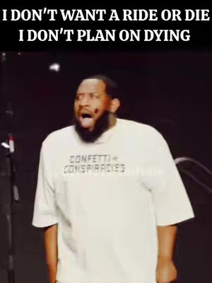 A medium shot shows a Black man with a beard and a surprised expression. Above him, black text states, "I DON'T WANT A RIDE OR DIE I DON'T PLAN ON DYING." He wears a white t-shirt with the words "CONFETTI CONSPIRACIES" printed across the chest.