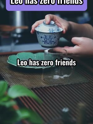 The image shows a close-up of a person holding a teacup, with text overlays. The cup is white with blue patterns. Beneath the cup is a glass teacup, a green tray, and a bamboo mat. The background is slightly blurred, adding depth to the image with text overlays about astrology signs.