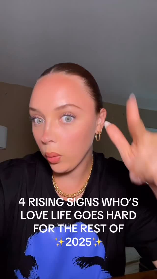 A woman is looking directly towards the camera with an expression of surprise or intrigue. She's holding up two fingers in a peace sign. Text overlays at the bottom say, '4 RISING SIGNS WHO'S LOVE LIFE GOES HARD FOR THE REST OF 2025'.
