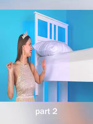 A woman in a sparkly dress and crown gestures dramatically in front of a white bed with a blue background. Below the bed, the hook displays "part 2".