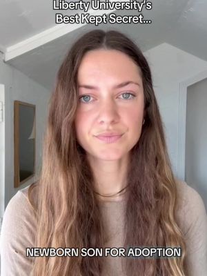 A medium shot shows a woman with long, light brown hair looking directly at the camera with a neutral expression. Text overlays at the top and bottom of the image. The background is a plain wall. The woman appears to be in an indoor setting.