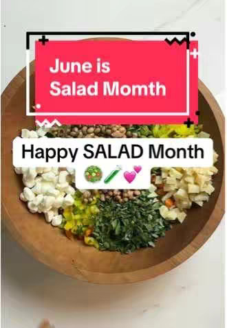 A wooden bowl filled with various chopped salad ingredients, arranged in sections. A red banner with white text that says June is Salad Month sits at the top of the bowl. A white banner with black border that says Happy SALAD Month. There are icons of a salad bowl, a cucumber, and pink hearts next to the text.
