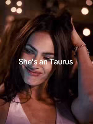 The cover image shows a person from the chest up with their face centered. She has dark hair and is smiling slightly, with a hand touching her hair. Text that reads "She's an Taurus" is overlaid on the image.