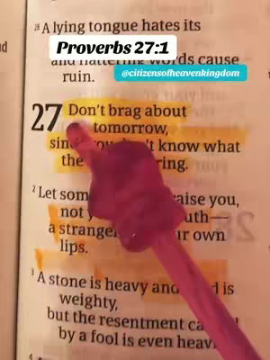 The image is a close-up shot of an open book, likely a Bible, with a highlighted passage in yellow. A pink object, possibly a finger, is pointing at the text. The text is mostly in English, and the overall composition is simple with a clear focus on the biblical verse and the interaction with it.