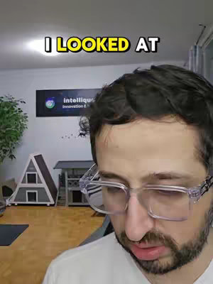 The cover image shows a man wearing glasses staring intently at something off-camera. The text overlay says "I LOOKED AT" in a yellow and white font. The background is a room with a sign on the wall and a small A-frame house.
