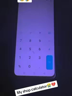 The image shows a smartphone screen displaying a calculator interface, set against a dark background. The phone is positioned at an angle, with the calculator's numerical buttons and operational symbols clearly visible. Text at the bottom reads 'My shop calculator,' with associated emojis.