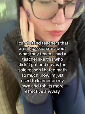 A close-up shot features a person with glasses, a nose ring, and dark hair framing their face. The person is touching their cheek and forehead with a hand. overlaid text in a white font is present, relaying text on a school experience.