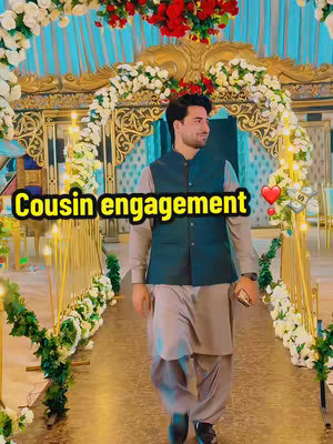 A man in traditional South Asian clothing walks towards the camera on a pathway decorated with floral arrangements and gold accents. Text overlayed reads "Cousin engagement".