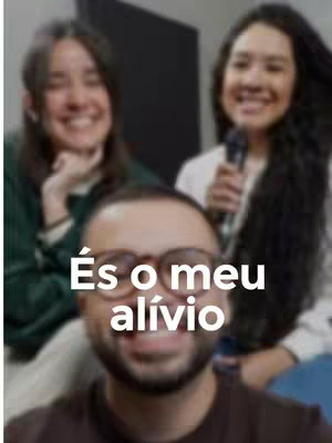 The cover image shows a selfie with three people. The foreground is dominated by a man with glasses, his face blurred. Behind him are two women, slightly out of focus as well. The text overlay 'És o meu alívio' is centered in white letters.