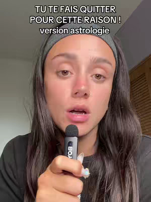 The cover image features a woman close up speaking into a microphone. Text overlay is visible at the top in a bold font. The woman has brown hair pulled back with a grey headband, a nose ring, and a dark colored top. She has a neutral-looking expression and is positioned center frame.